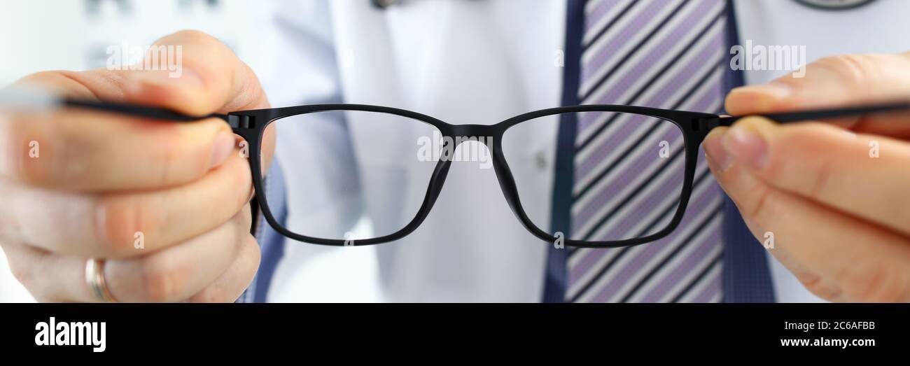 Male medicine doctor hands giving pair of black glasses Stock Photo Alamy