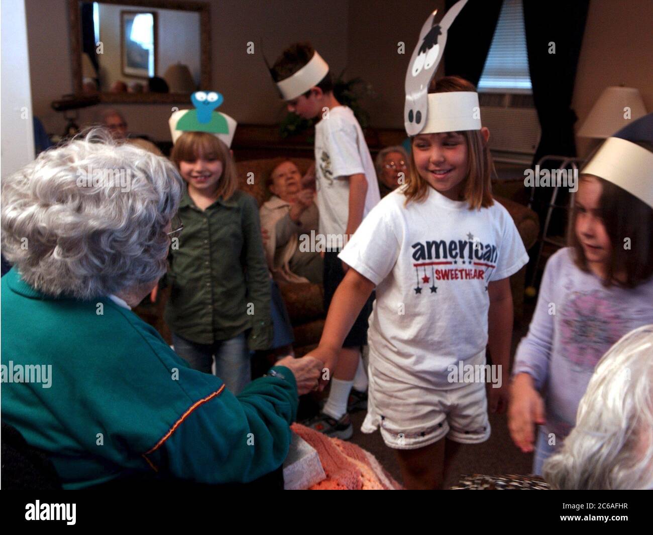 Austin, Texas USA, April 30, 2004: First grade students from Barton Hills Elementary School visit elderly residents at an assisted living center in south Austin.  ©Bob Daemmrich Stock Photo