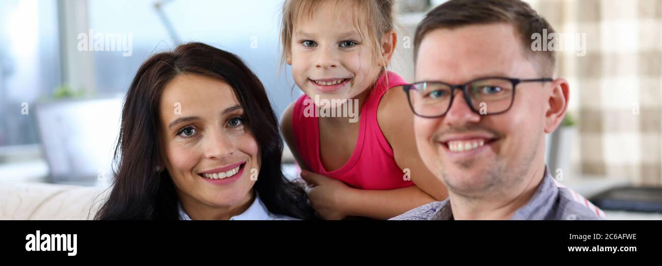 Cheerful parents with daughter at home Stock Photo