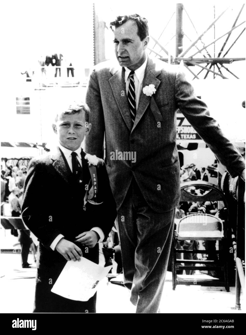 H049-02 March 20, 1956: Nine-year-old  George W. Bush with his father, George H.W. Bush, at the commissioning ceremonies for the Scorpion off-shore drilling platform. The elder Bush was president of Zapata Oil, which ordered the ground-breaking drilling rig. ©George Bush Presidential Library Stock Photo