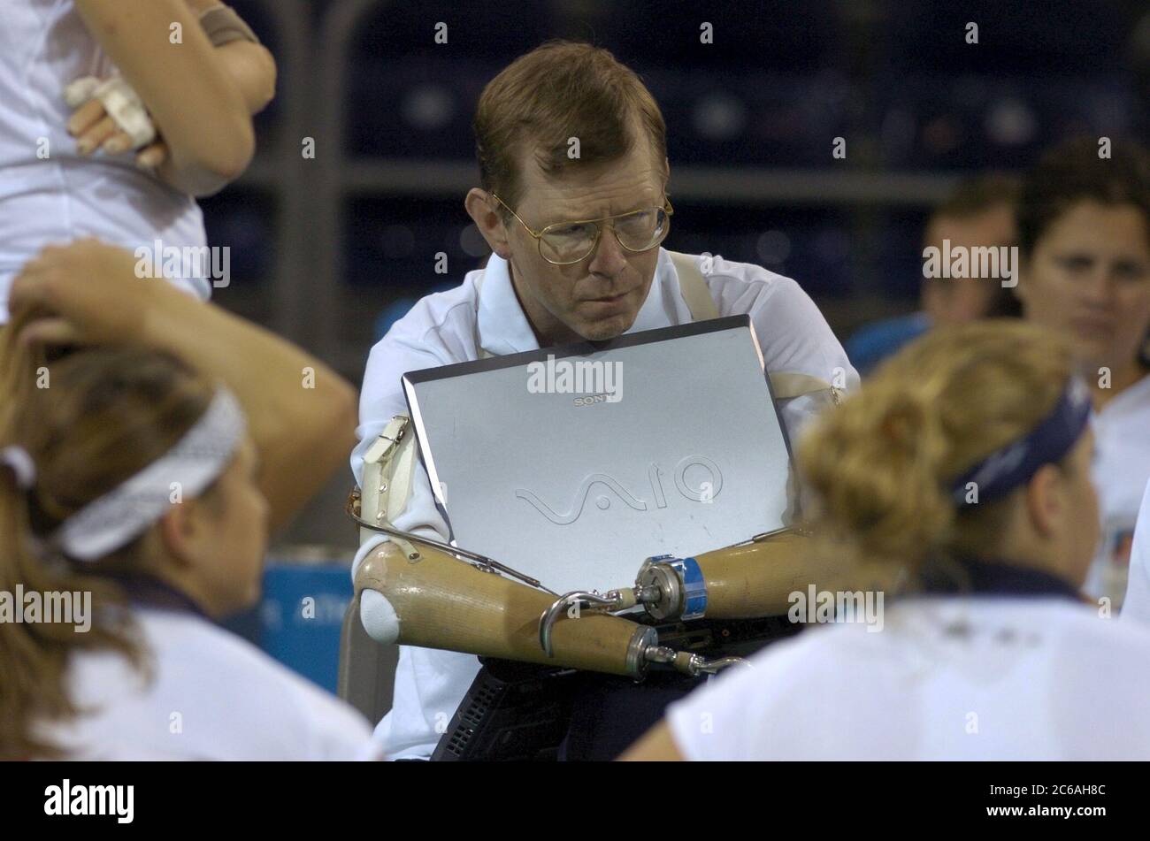 Athens, Greece 24SEP04: Sitting volleyball coach Mike Hulett of the USA team gives instructions to his players during a timeout at the Paralympics.  Hulett has prosthetic arms and one prosthetic leg. ©Bob Daemmrich Stock Photo