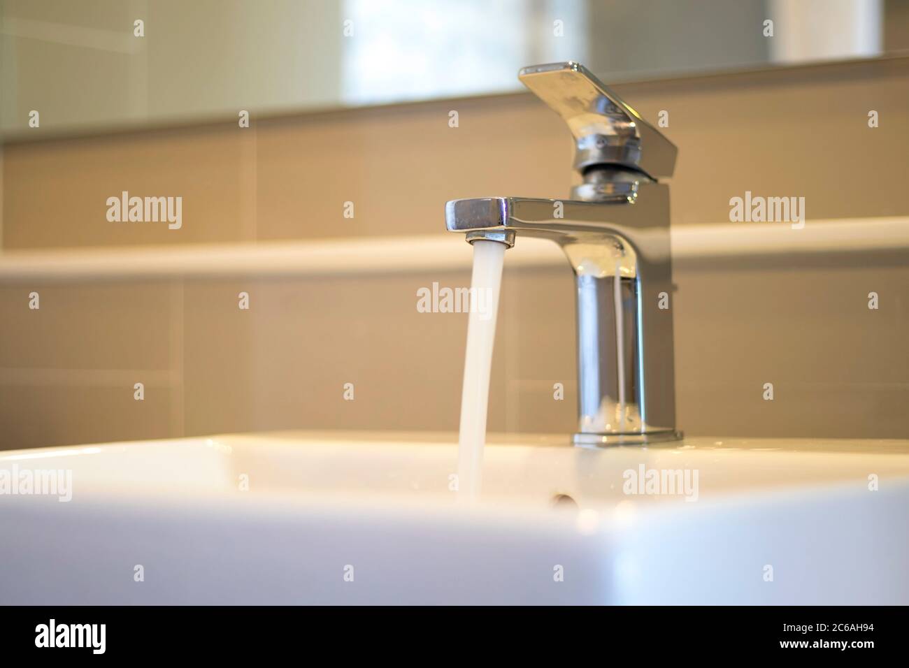 Water flows out of the tap on the sink Stock Photo - Alamy