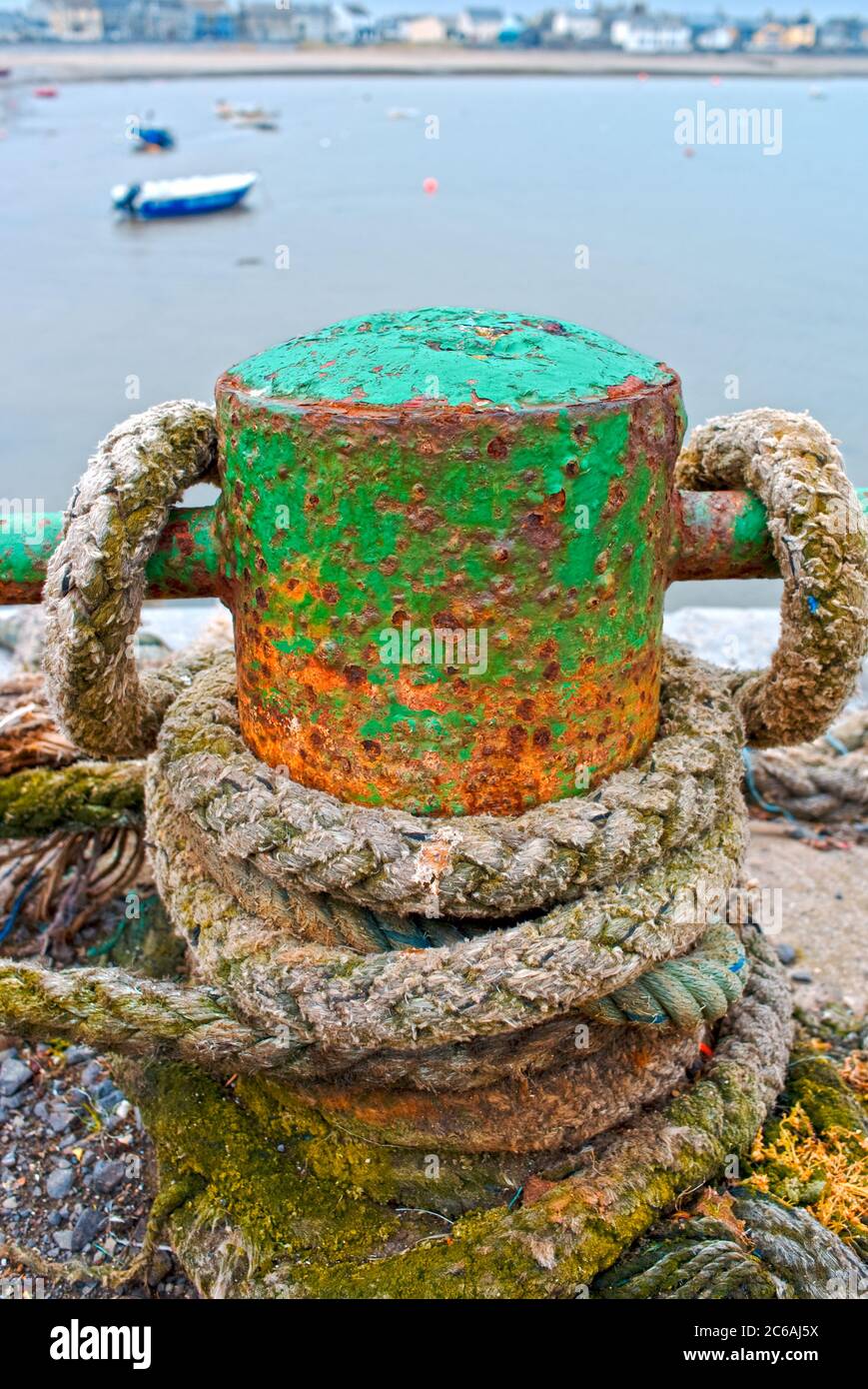 Rusty old cast iron bollard for mooring boats on the harbour at the seaside town of Skerries, county Dublin, Ireland Stock Photo