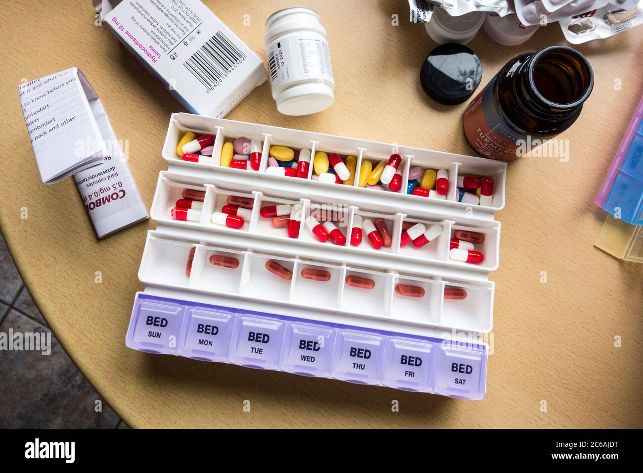 weekly medicines container being filled with pills Stock Photo