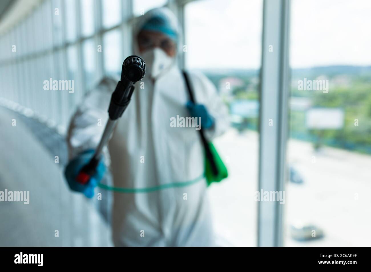 Man disinfector cleaning office space and window before work on corona virus pandamia. Stock Photo