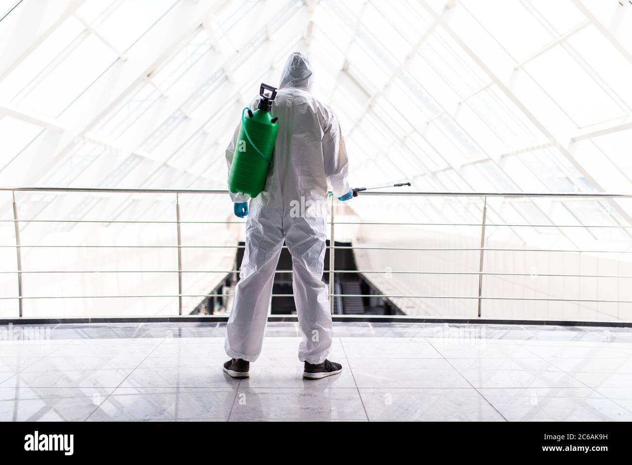 Disinfector man clean surfeces space in modern office to prevent corona virus. Stock Photo