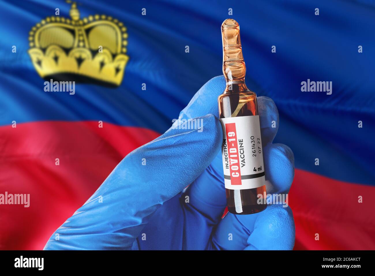 Liechtenstein flag with Coronavirus Covid-19 concept. Doctor with blue protection medical gloves holds a vaccine bottle. coronavirus covid 19 vaccine Stock Photo