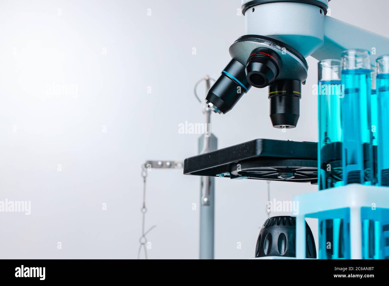 Close up of laboratory microscope with set of test tubes with blue ...