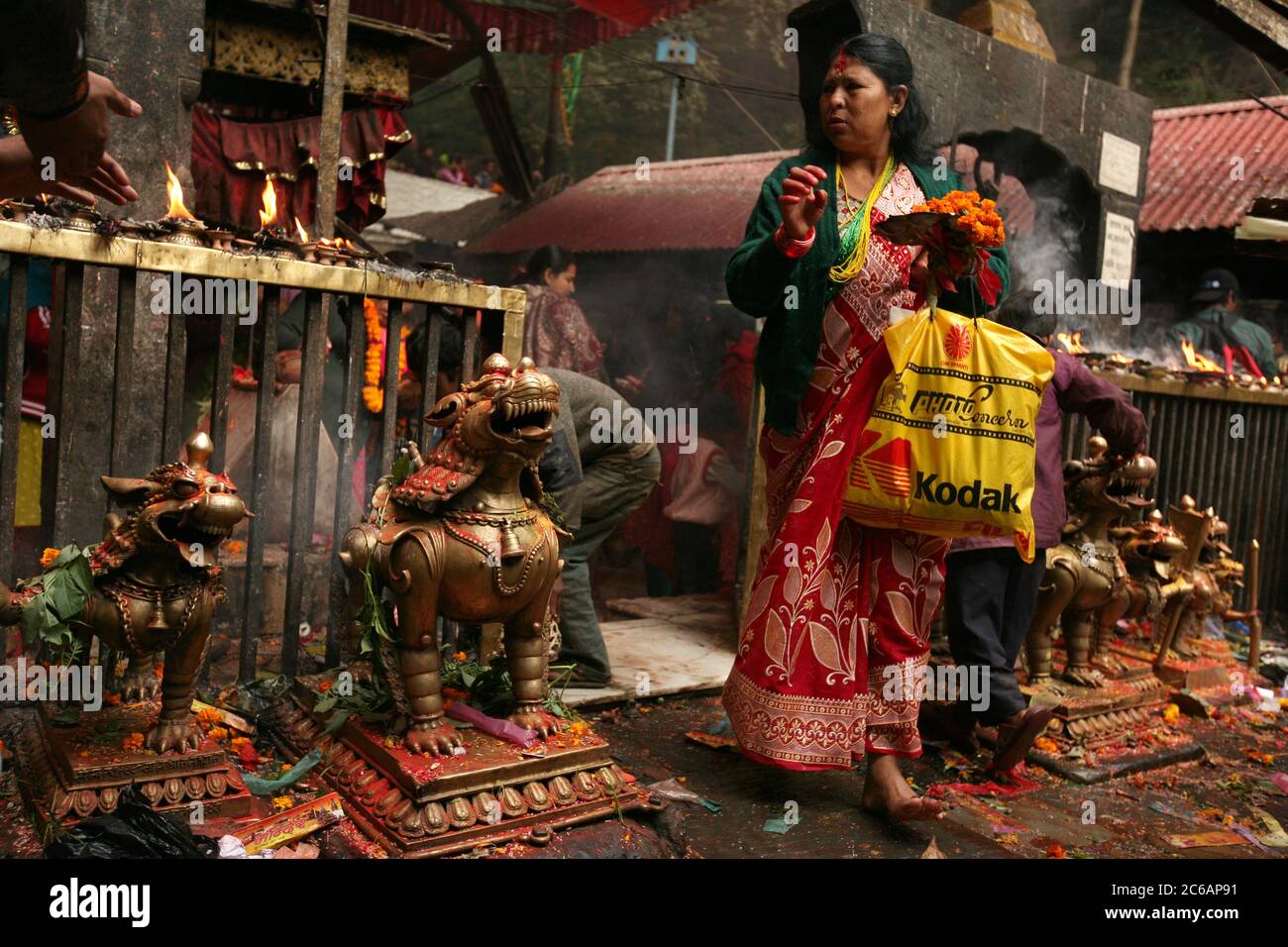 Nepalese woman leaves the main sanctuary in the Dakshinkali Temple near Kathmandu, Nepal. One of the major Hindu temples in Nepal dedicated to the goddess Kali is known for its animal sacrifices which take place in the main sanctuary. Stock Photo