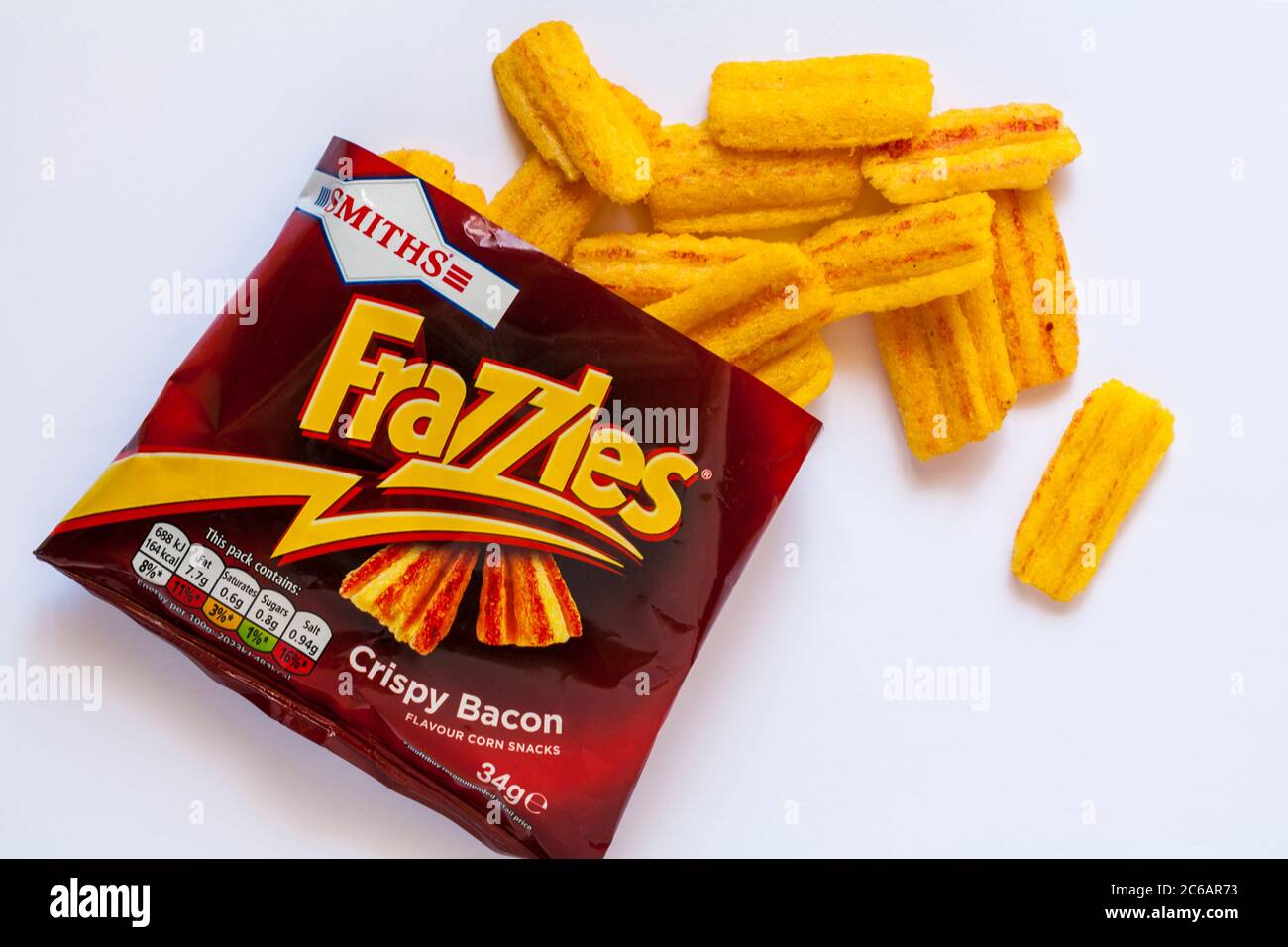 packet of Smiths Frazzles Crispy Bacon flavour corn snacks opened with contents spilled spilt set on white background Stock Photo