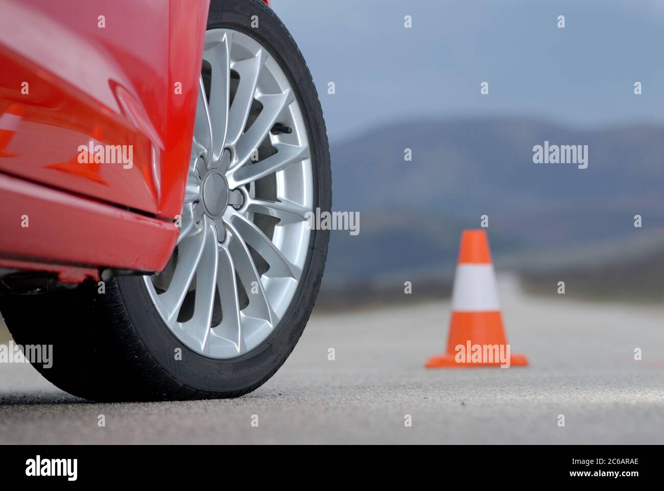 aluminium sport wheel on a red sport car and cone Stock Photo