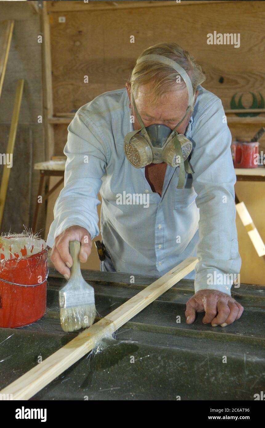 Flour Bluff Texas USA, December 7 2004: Stoner Boat Works, where veteran boat builder Robert Stoner wears a ventilator while using fiberglass to build a custom mold for a boat hull.  ©Bob Daemmrich Stock Photo