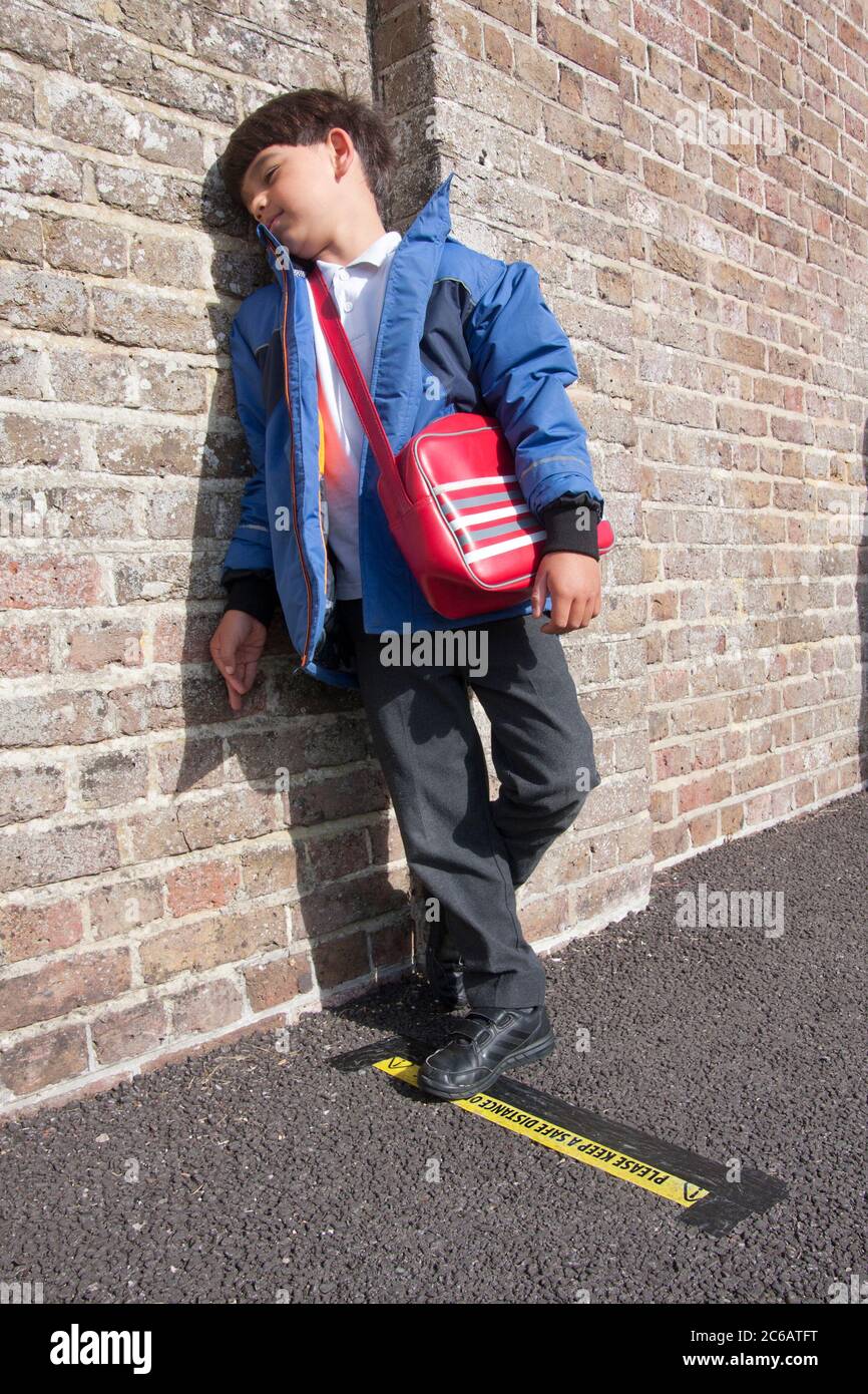 primary school child standing on social distancing line during Covid-19 outbreak 2020, England Stock Photo