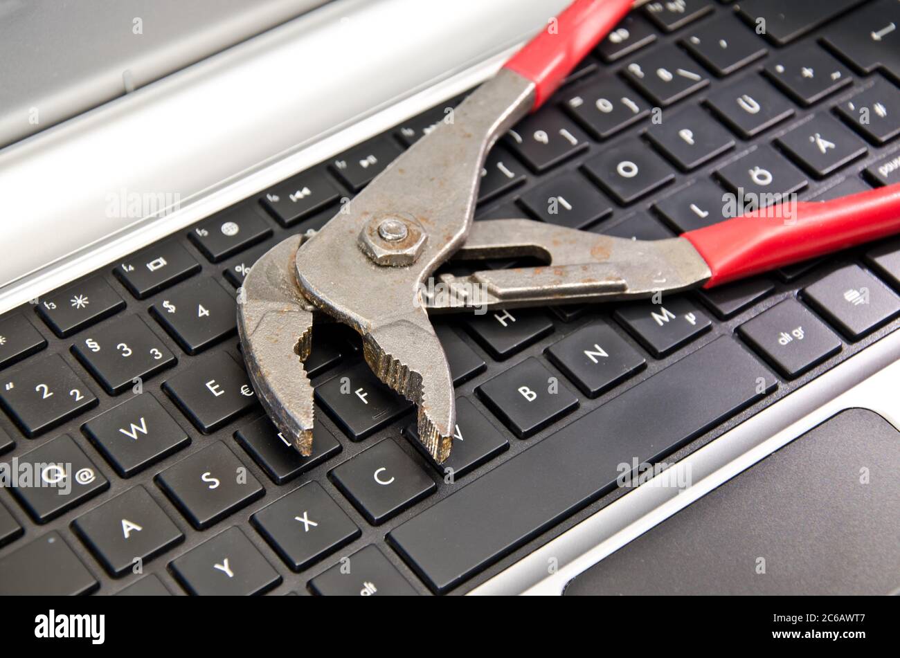 Wrench lying on computer keyboard Stock Photo
