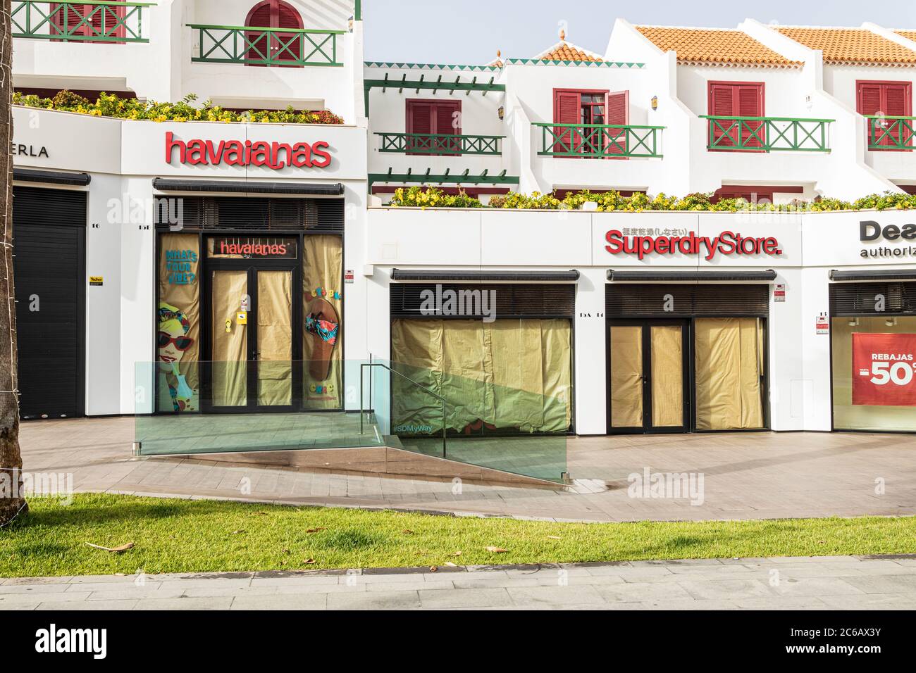 Shops closed with paper covered windows in the aftermath of the covid 19 lockdown, Playa de Las Americas, Tenerife, Canary Islands, Spain Stock Photo