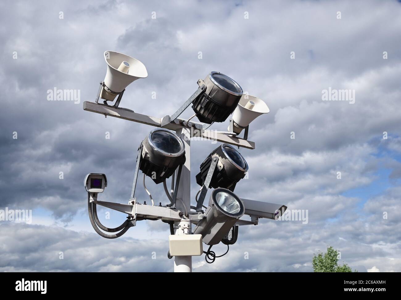 Close up of outdoor surveillance cameras, floodlights and loudspeakers on street pole Stock Photo