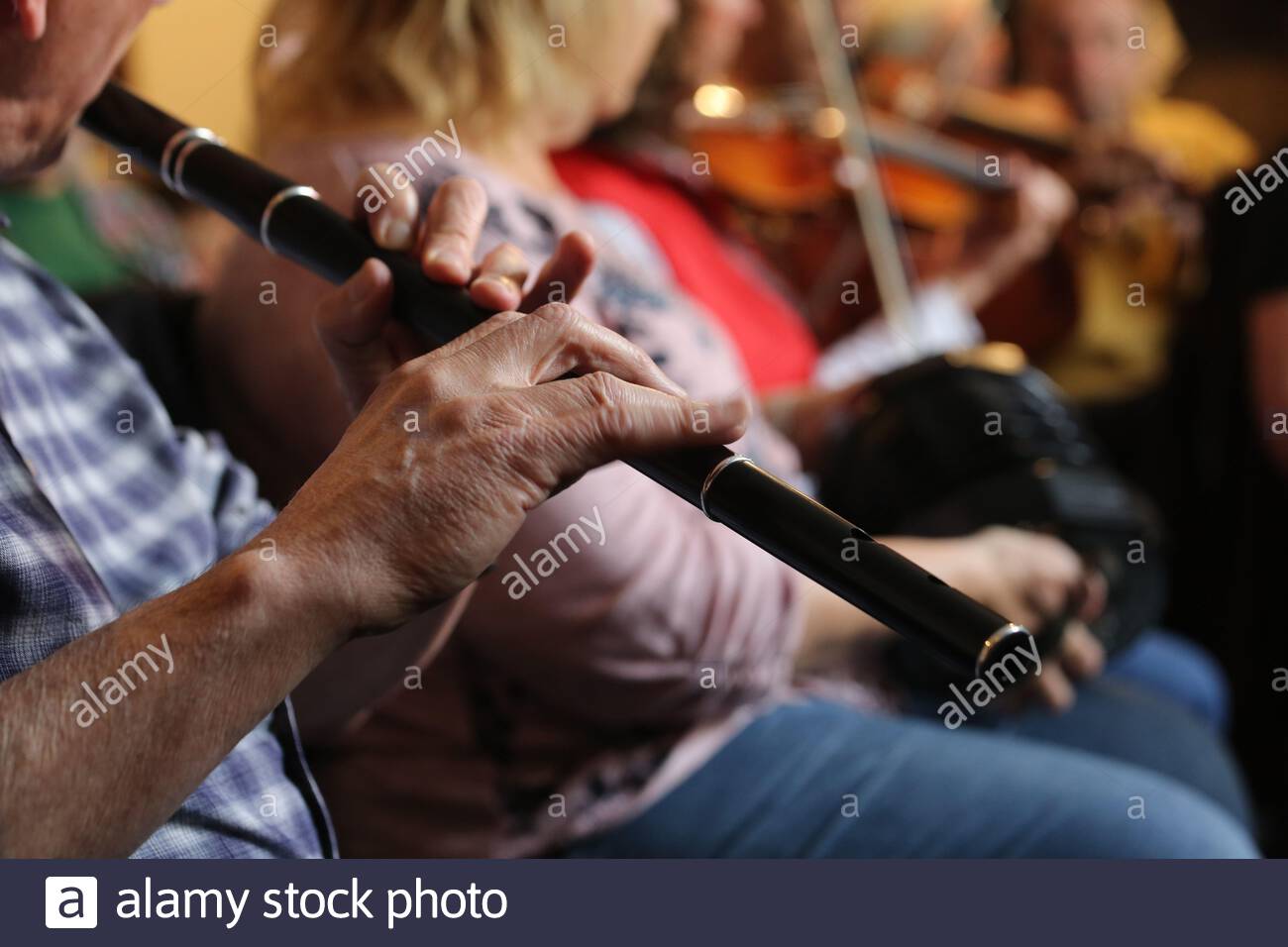 An Irish flute player and other traditional musicians during a Fleadh Cheoil session in Ennis County Clare. Stock Photo