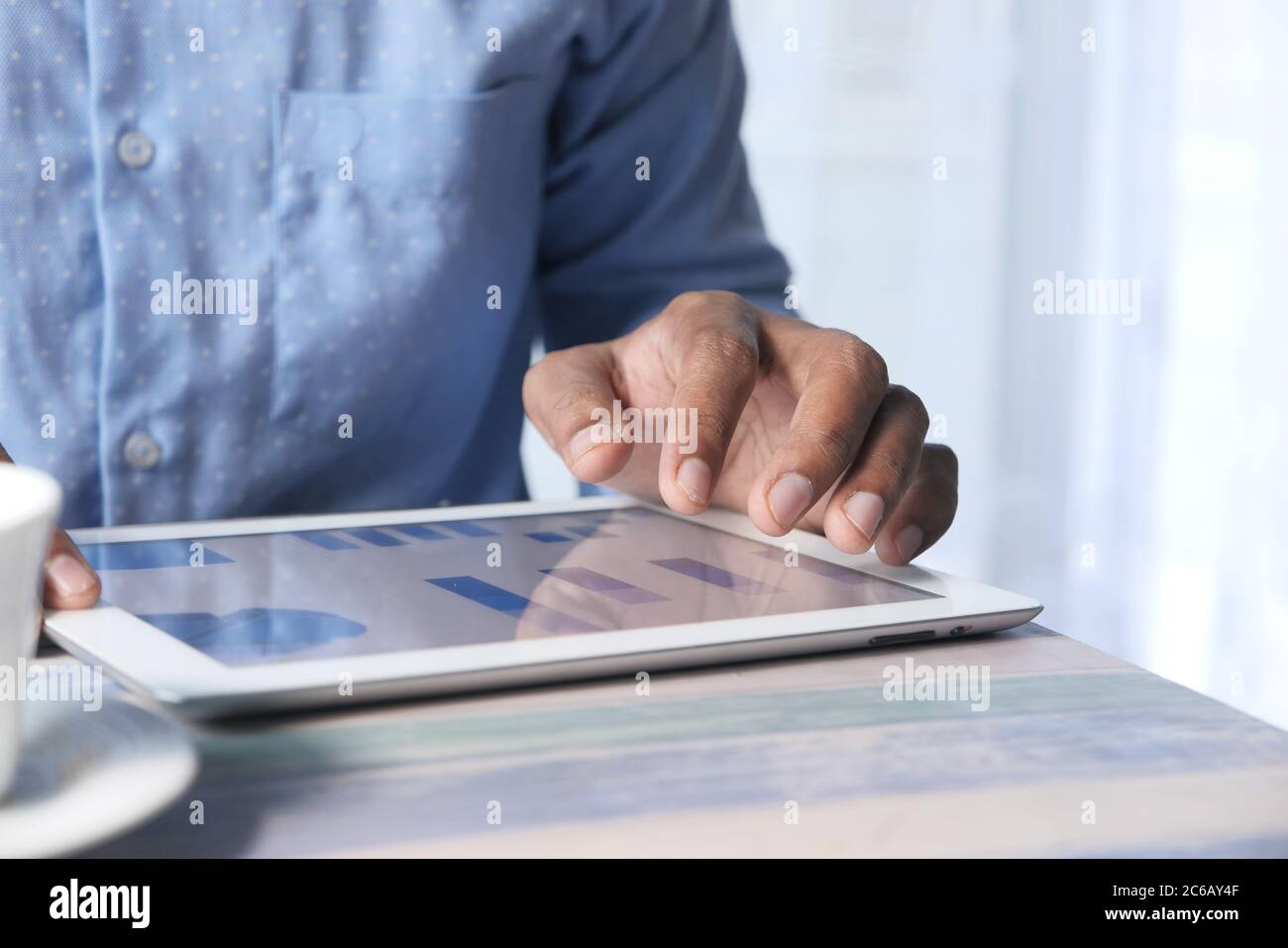 man's hand working on digital tablet at office desk, using self created ...