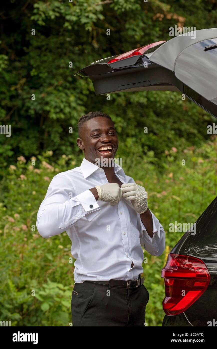 England, UK. 2020.  Car driver with the boot open seen changing his clothes Stock Photo