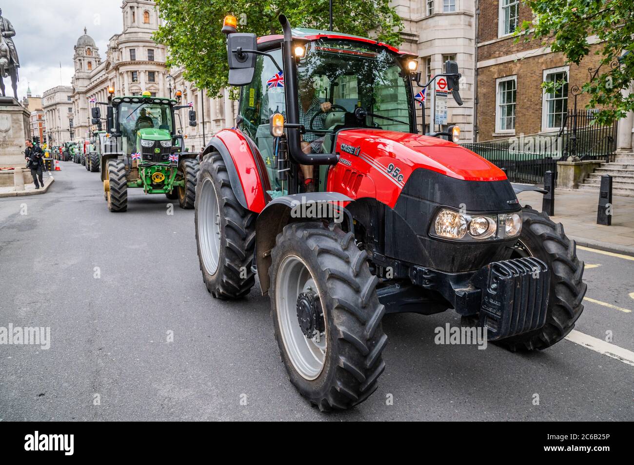 London, UK. 08th July, 2020. Heading down Whitehall and past Downing Street - A slow convoy of tractors drives from New Covent Garden Market to Westminster to object to a possible trade deal with the USA that does not respect British food standards. Save British Farming and Extinction Rebellion protest on the day Rishi Sunak delivers a summer economic update to Parliament. Credit: Guy Bell/Alamy Live News Stock Photo