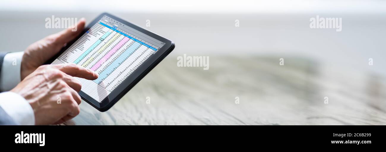 Man Holding Tablet With Online Spreadsheet Data Document Stock Photo