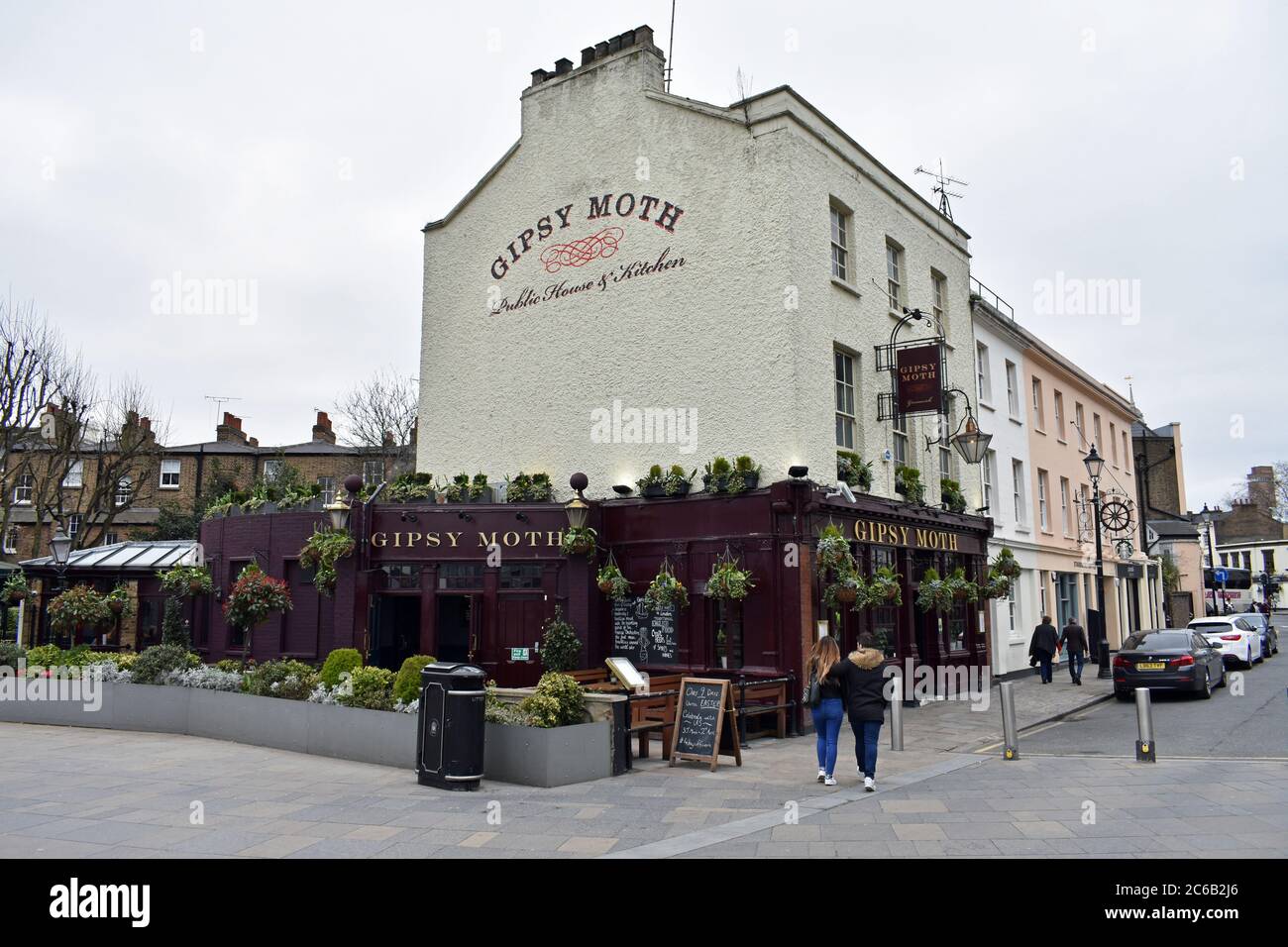 An old fashioned british pub, The Gipsy Moth, in Greenwich, London. The pub has a burgundy lower half with gold writing and a off white main structure. Stock Photo