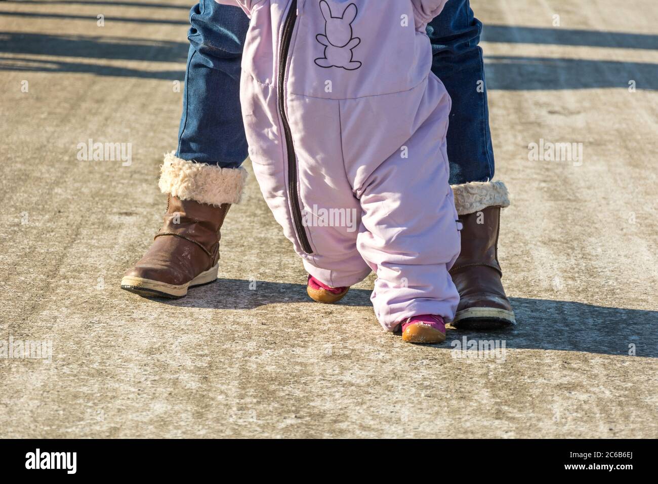 First steps of a toddler in winter garments Stock Photo