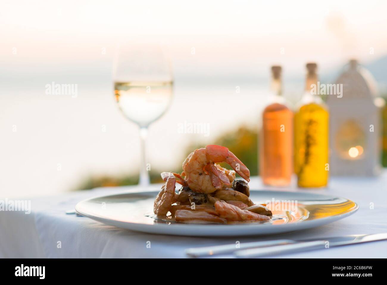 Prawns with white wine at sunset at a restaurant in Pefkos, Rhodes, Dodecanese, Greek Islands, Greece, Europe Stock Photo