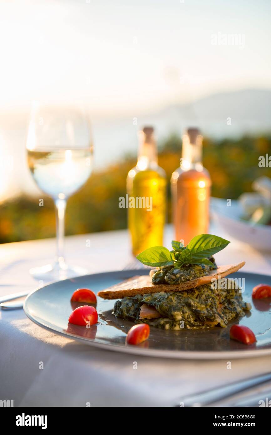 Spanikopita with white wine at sunset at a restaurant in Pefkos, Rhodes, Dodecanese, Greek Islands, Greece, Europe Stock Photo
