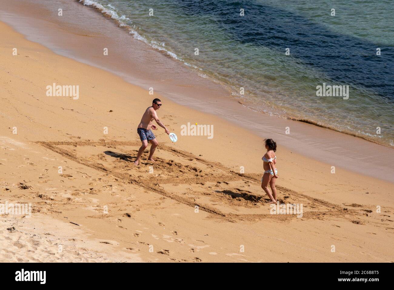 Father playing beach tennis with his daughter Stock Photo