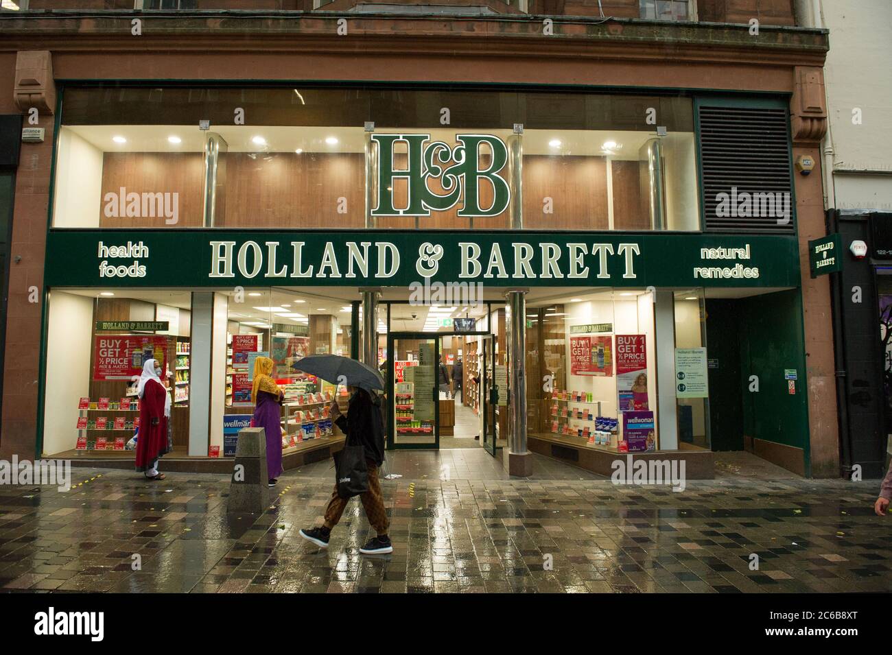 Glasgow, Scotland, UK. 8th July, 2020. Pictured: People out in the rain shopping in Glasgow City Centre as the coronavirus (COVID19) lockdown has eased, and from this Friday 10th July, people will be required to wear a face covering when going into a shop in a bid to stop the spread of the coronavirus. Credit: Colin Fisher/Alamy Live News Stock Photo