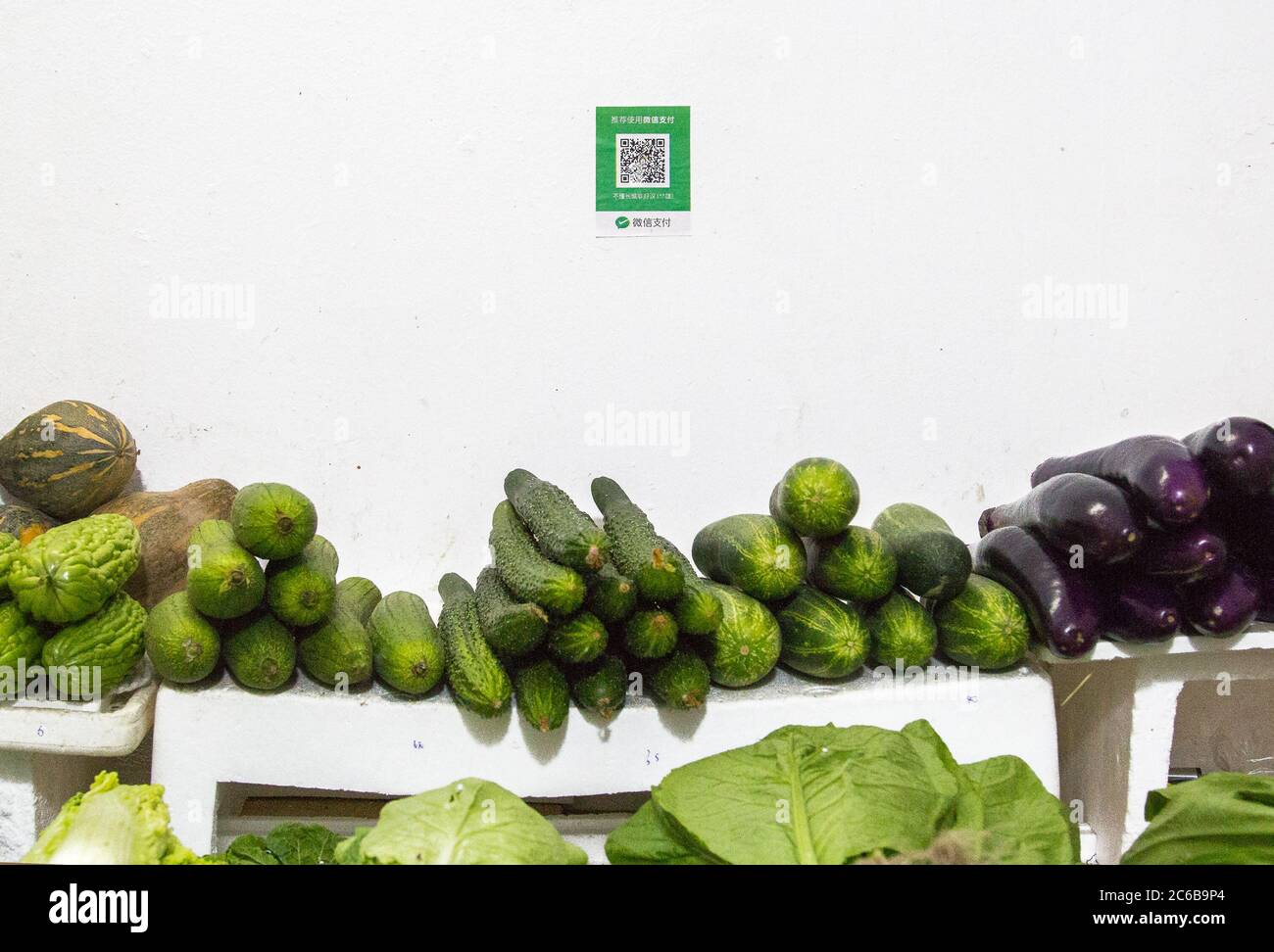 Shenzhen, China - November 14 2018:  Qr codes for cashless payment with smart phones stands over a street vegetable booth in China. Digitalization, su Stock Photo