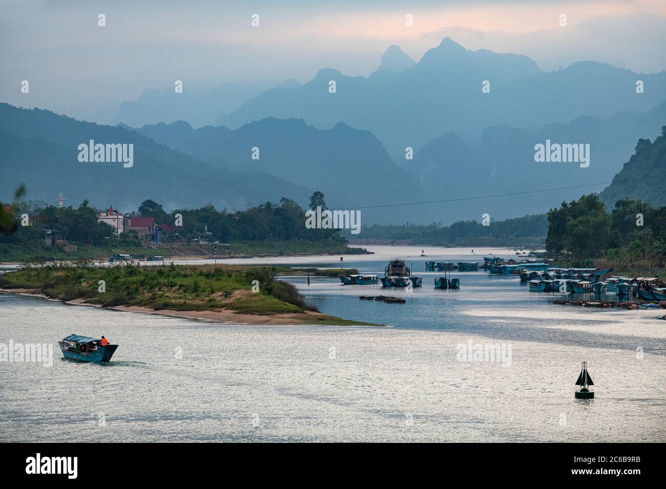River boat on the Song Con River with the limestone mountains in the background, Phong Nha-Ke Bang National Park, UNESCO World Heritage Site, Vietnam, Stock Photo