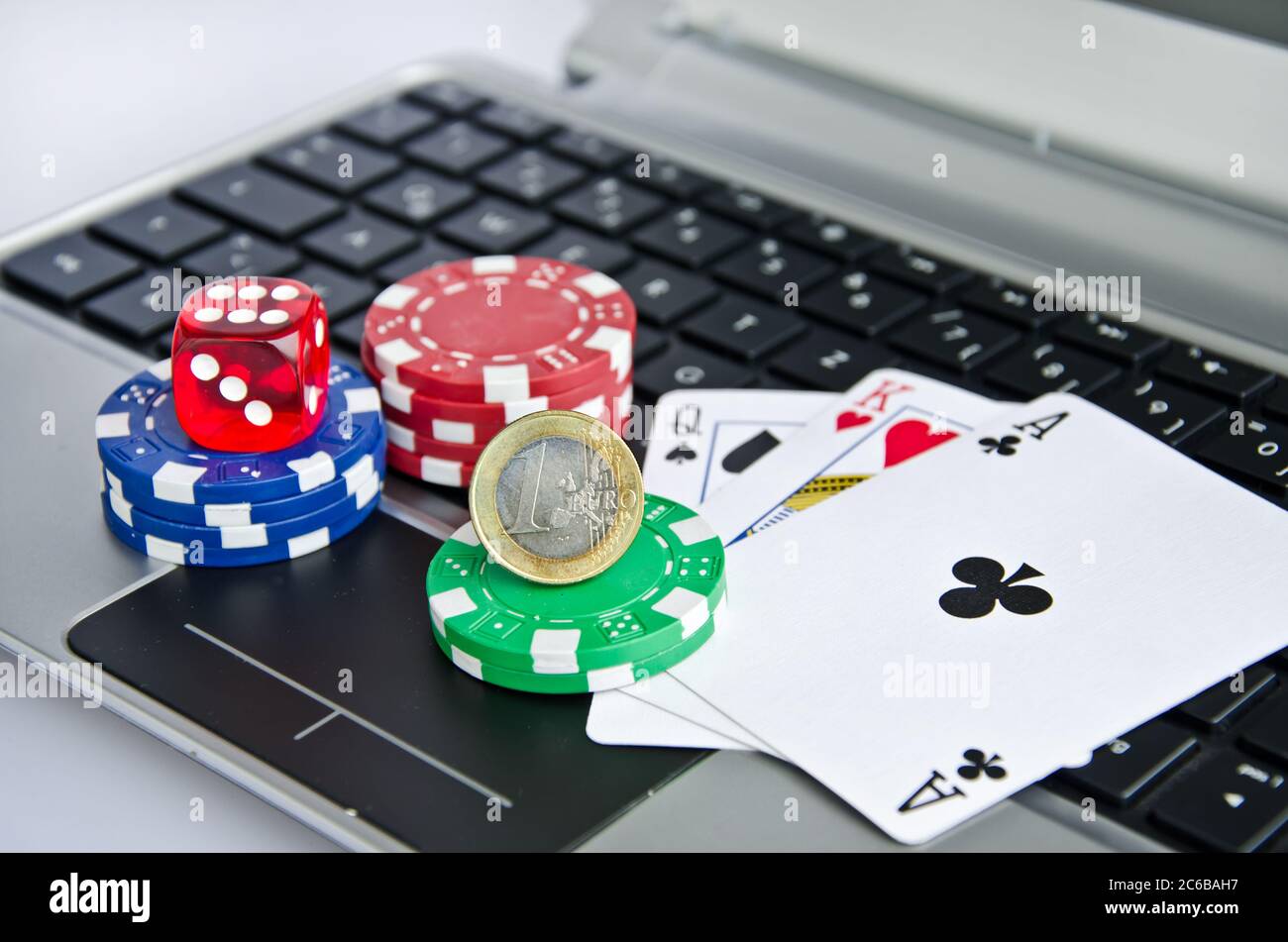 Playing cards, casino chips and Euro coin on a laptop keyboard symbolizing online gambling Stock Photo