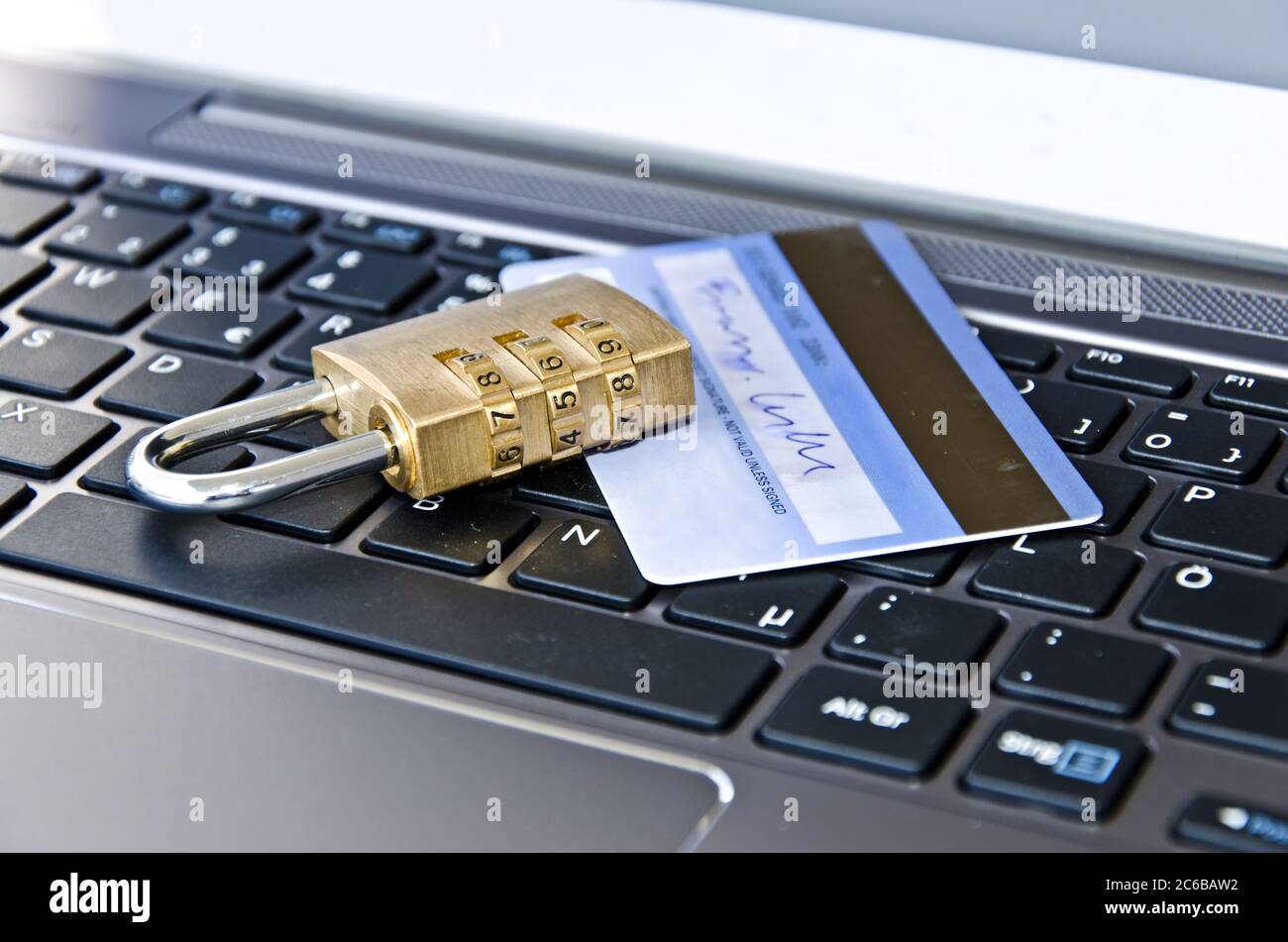 Credit card with padlock lying on computer keyboard symbolizing secure online payments Stock Photo