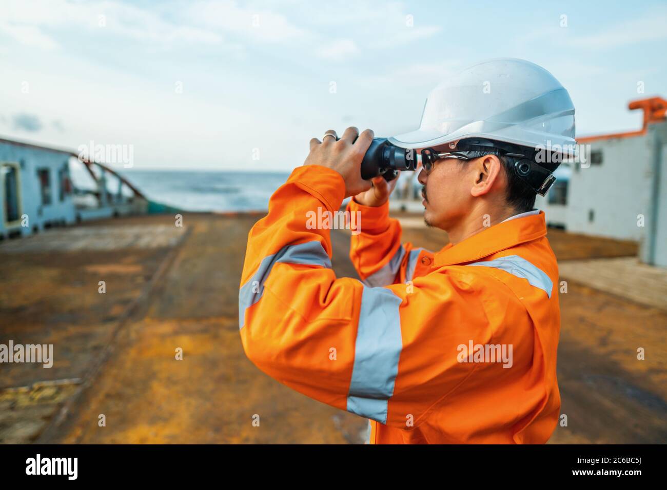 Filipino deck Officer on deck of vessel or ship , wearing PPE personal