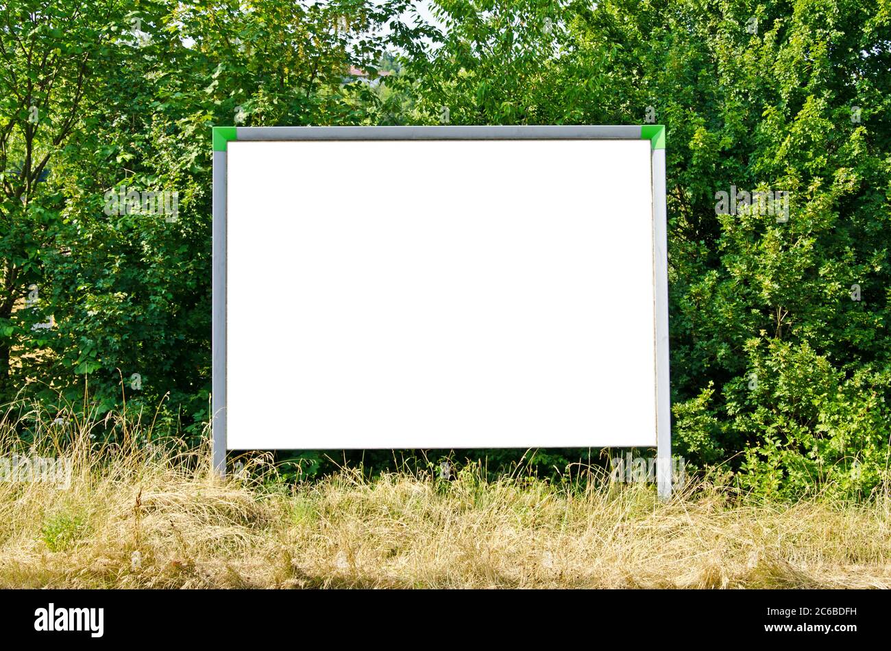Blank billboard in front of green trees Stock Photo - Alamy