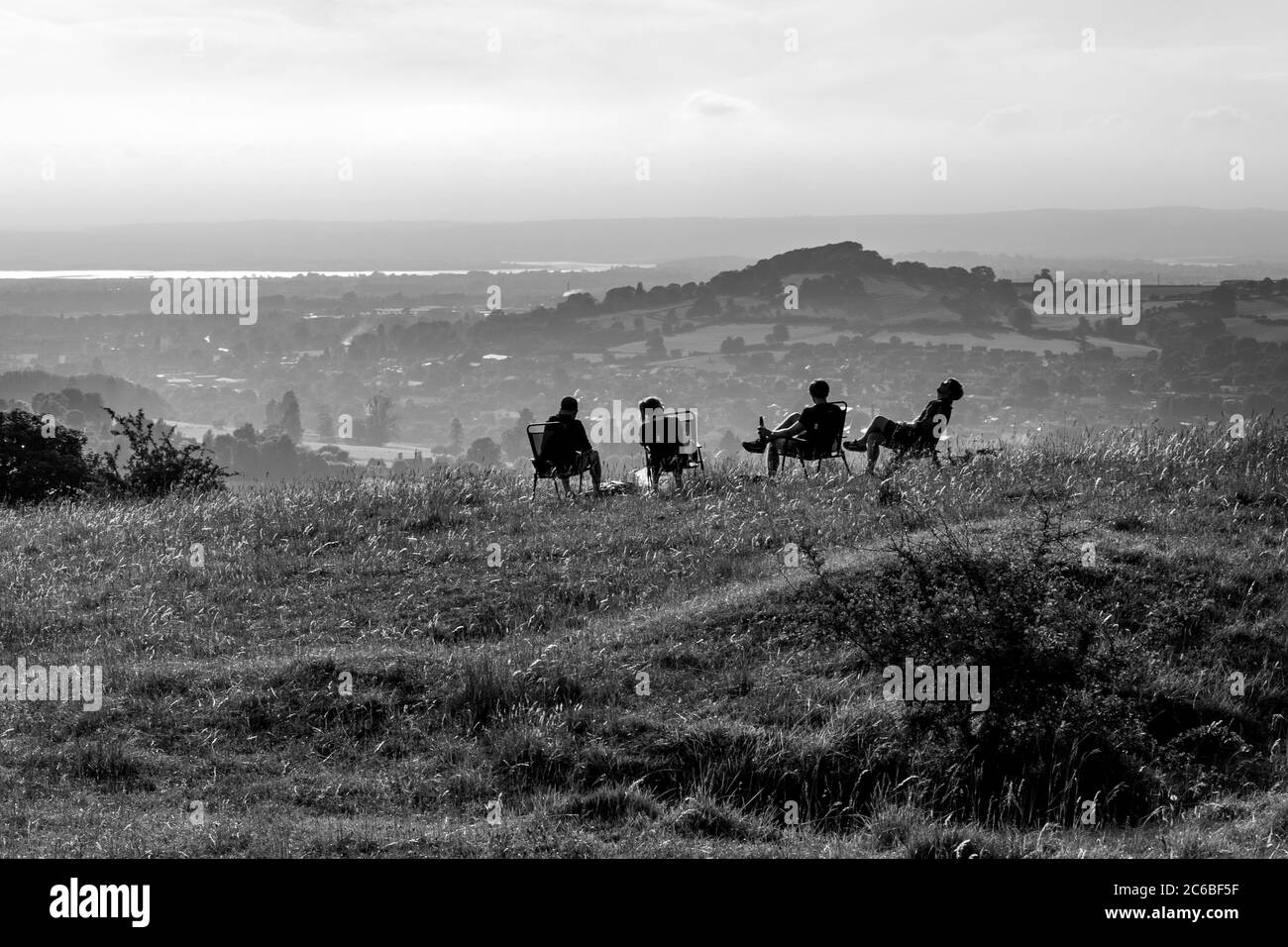 A group of friends enjoying a socially distanced drink on a hill in Stroud, Gloucestershire Stock Photo