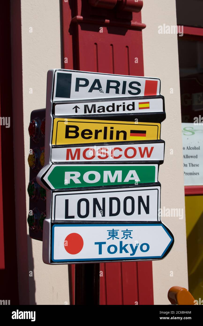 Sign with various city names, directions, this way to, directional, fun, folly, lighthearted, Paris, Madrid, Berlin, Moscow, Roma, London,Tokyo Stock Photo