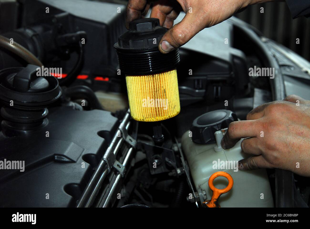 Repairman holding an old oil filter, replacement of oil filter Stock