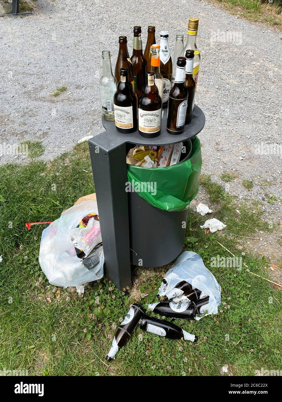 Overflowing garbage can, with lots of garbage, glass bottles next to it, party waste, at a lookout point in the forest, Korte Klippe, Essen, NRW, Germ Stock Photo