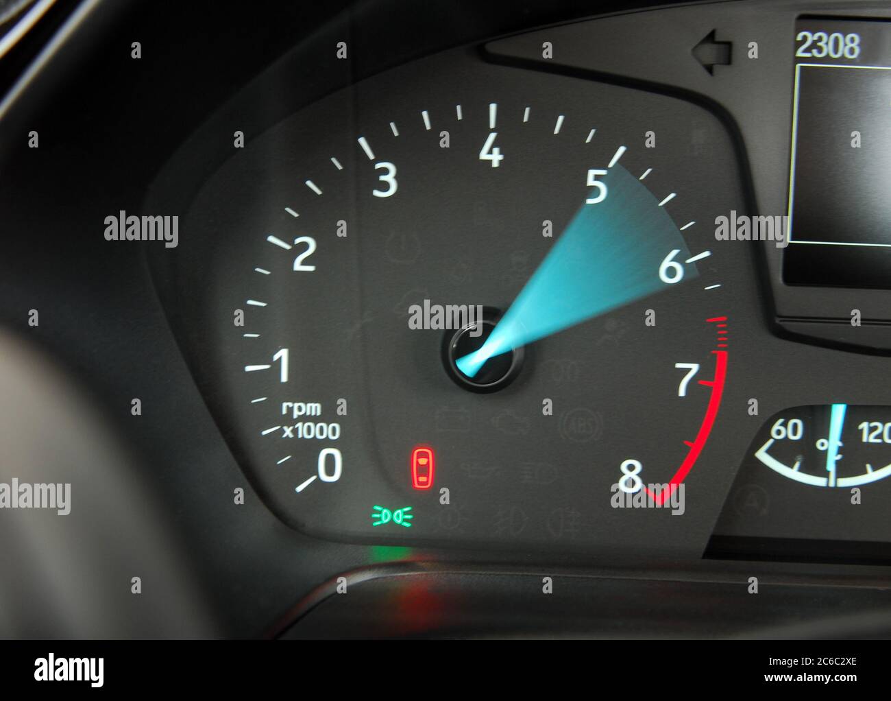 Car Tachometer. Tachometer reaching the red zone, sports car inside