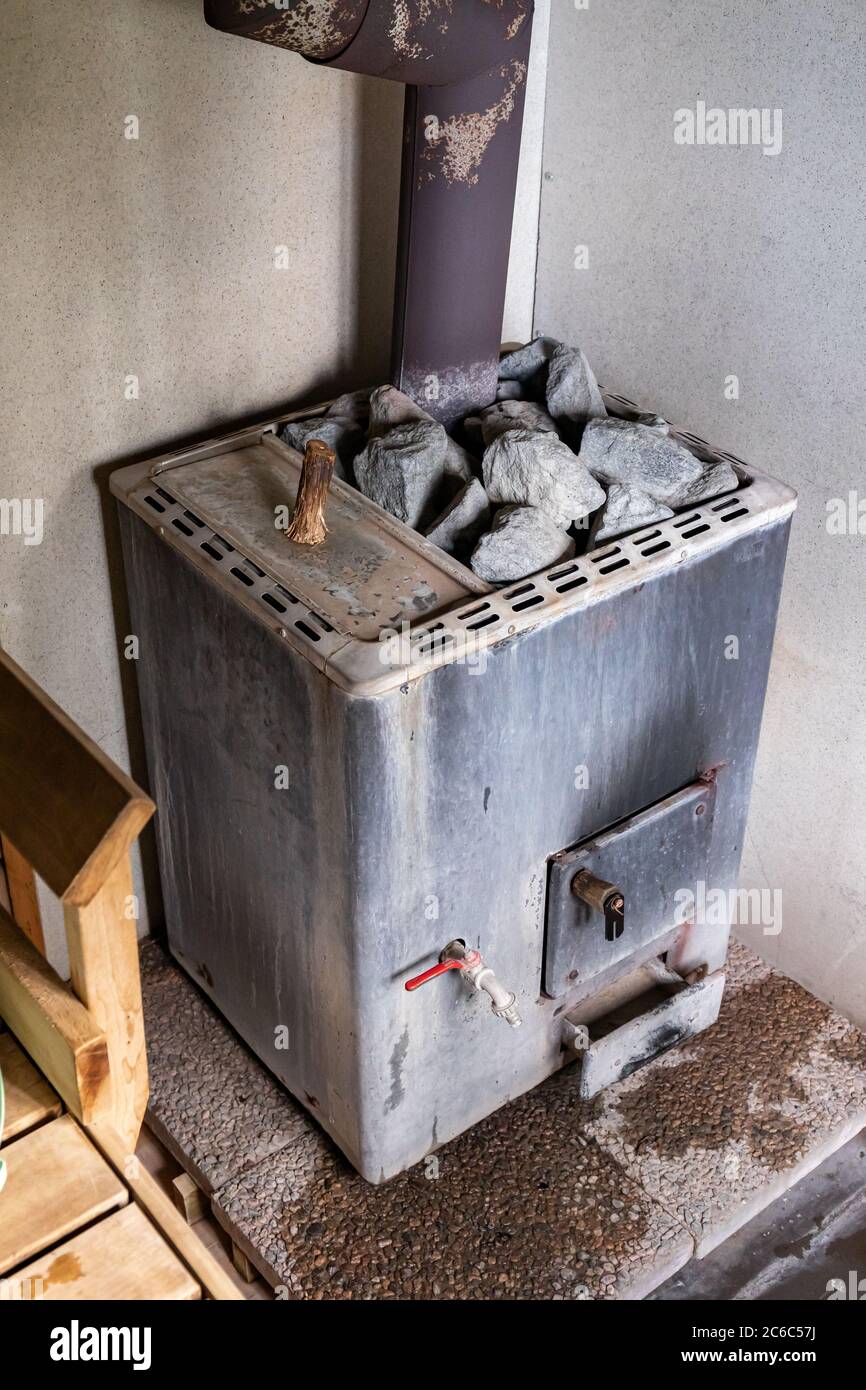 Old wood burning sauna heater stove with water heater in Orivesi, Finland Stock Photo