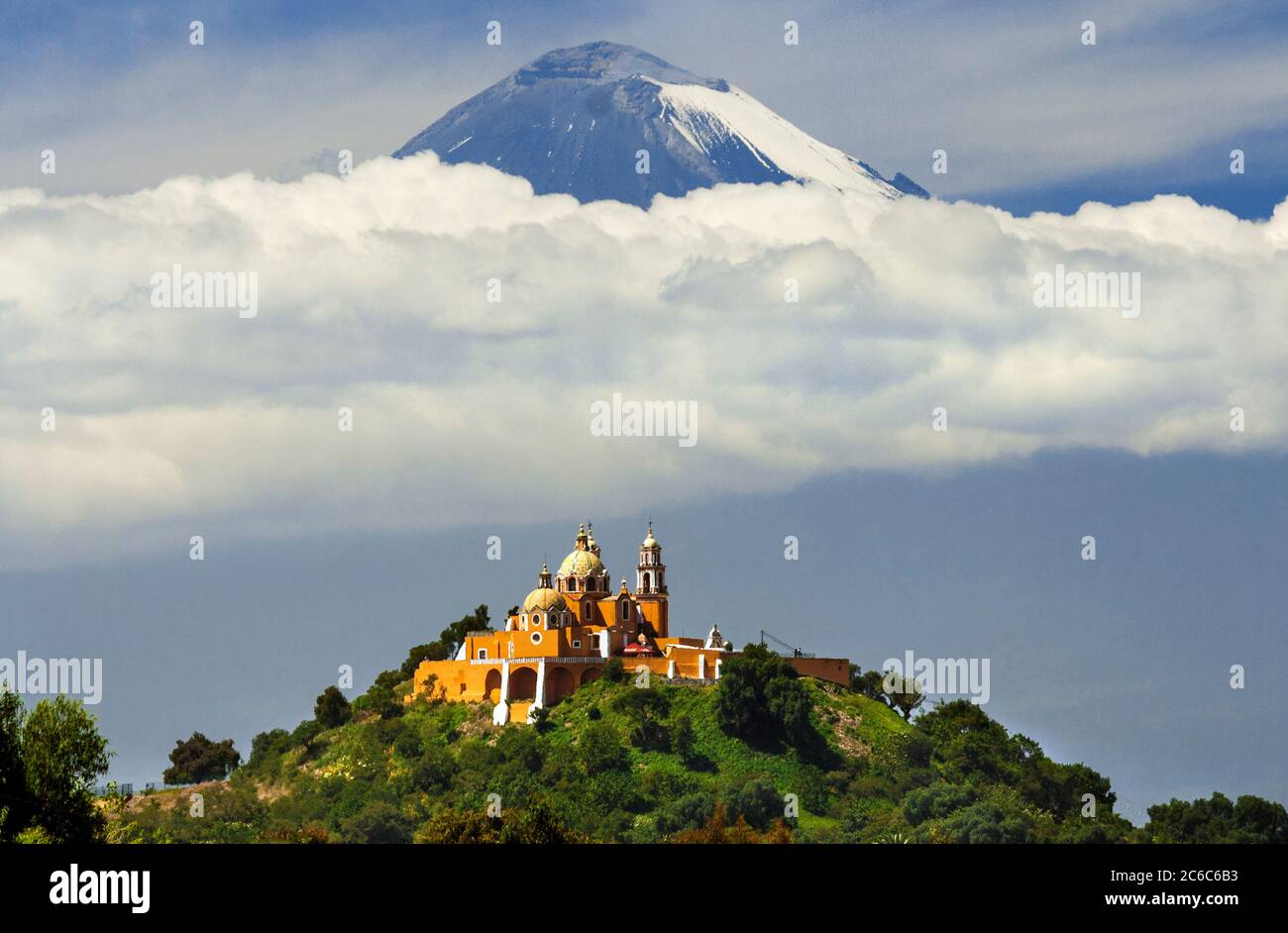 Santuario de la Virgen de los Remedios (church) atop the Gran Piramide de Tepanapa with Popocatepetl Volcano in the background in Cholula, Puebla, Mex Stock Photo