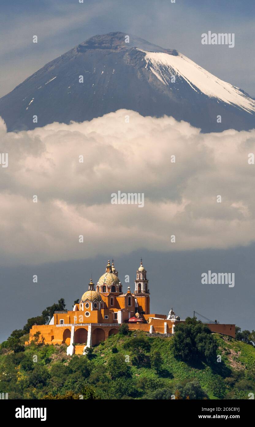 Santuario de la Virgen de los Remedios (church) atop the Gran Piramide de Tepanapa with Popocatepetl Volcano in the background in Cholula, Puebla, Mex Stock Photo