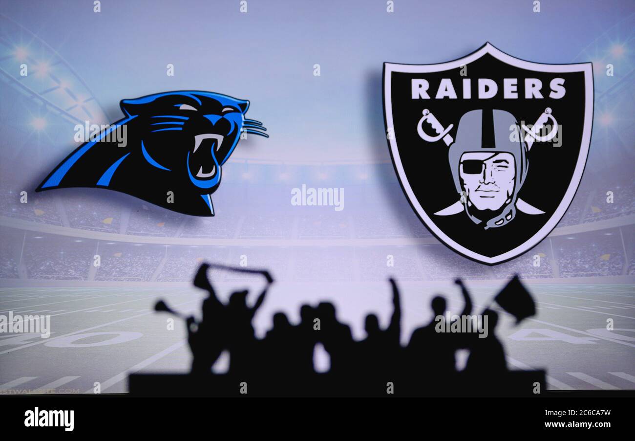 Carolina Panthers vs. Las Vegas Raiders. Fans support on NFL Game. Silhouette of supporters, big screen with two rivals in background. Stock Photo