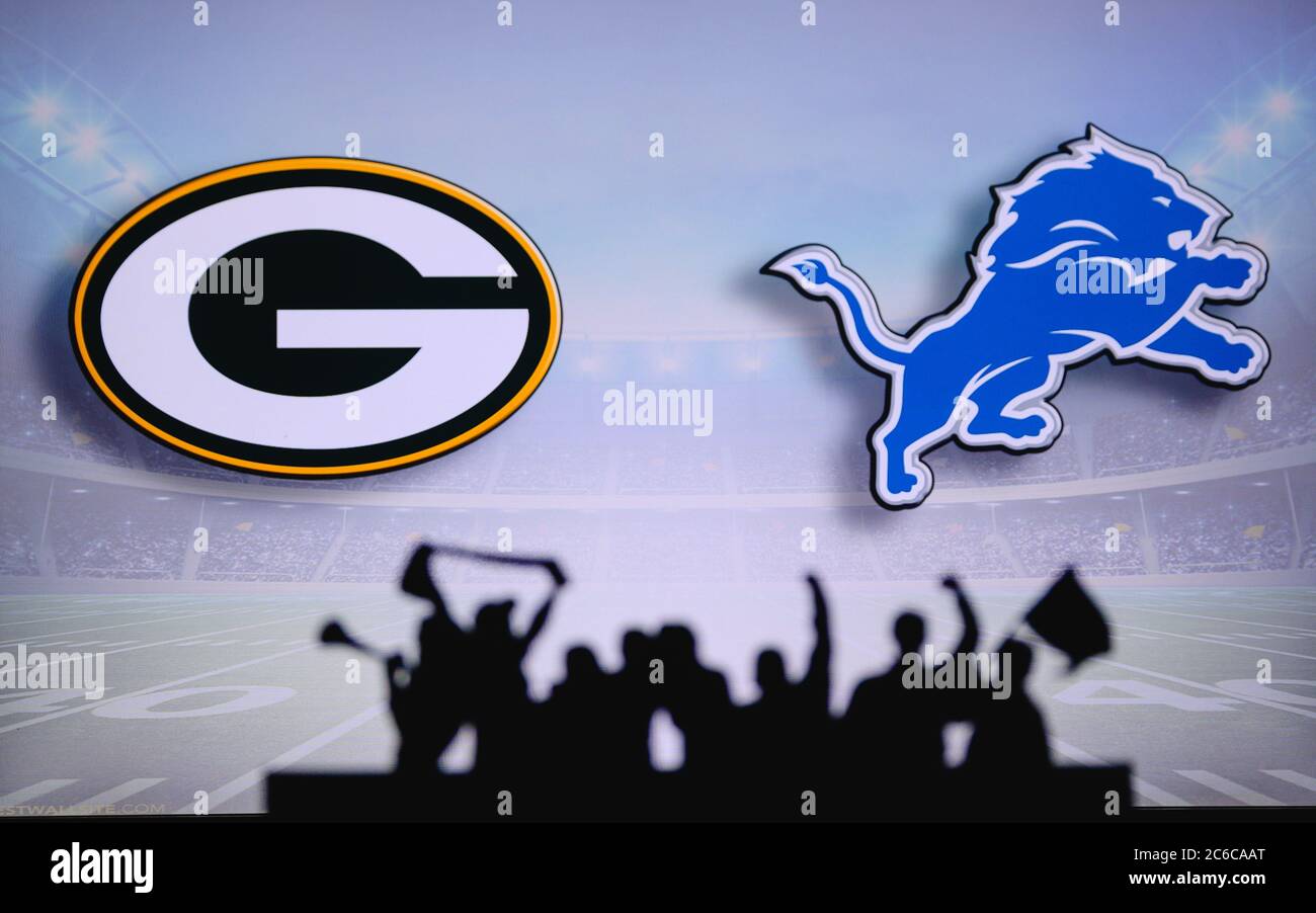 Green Bay Packers vs. Detroit Lions. Fans support on NFL Game. Silhouette of supporters, big screen with two rivals in background. Stock Photo