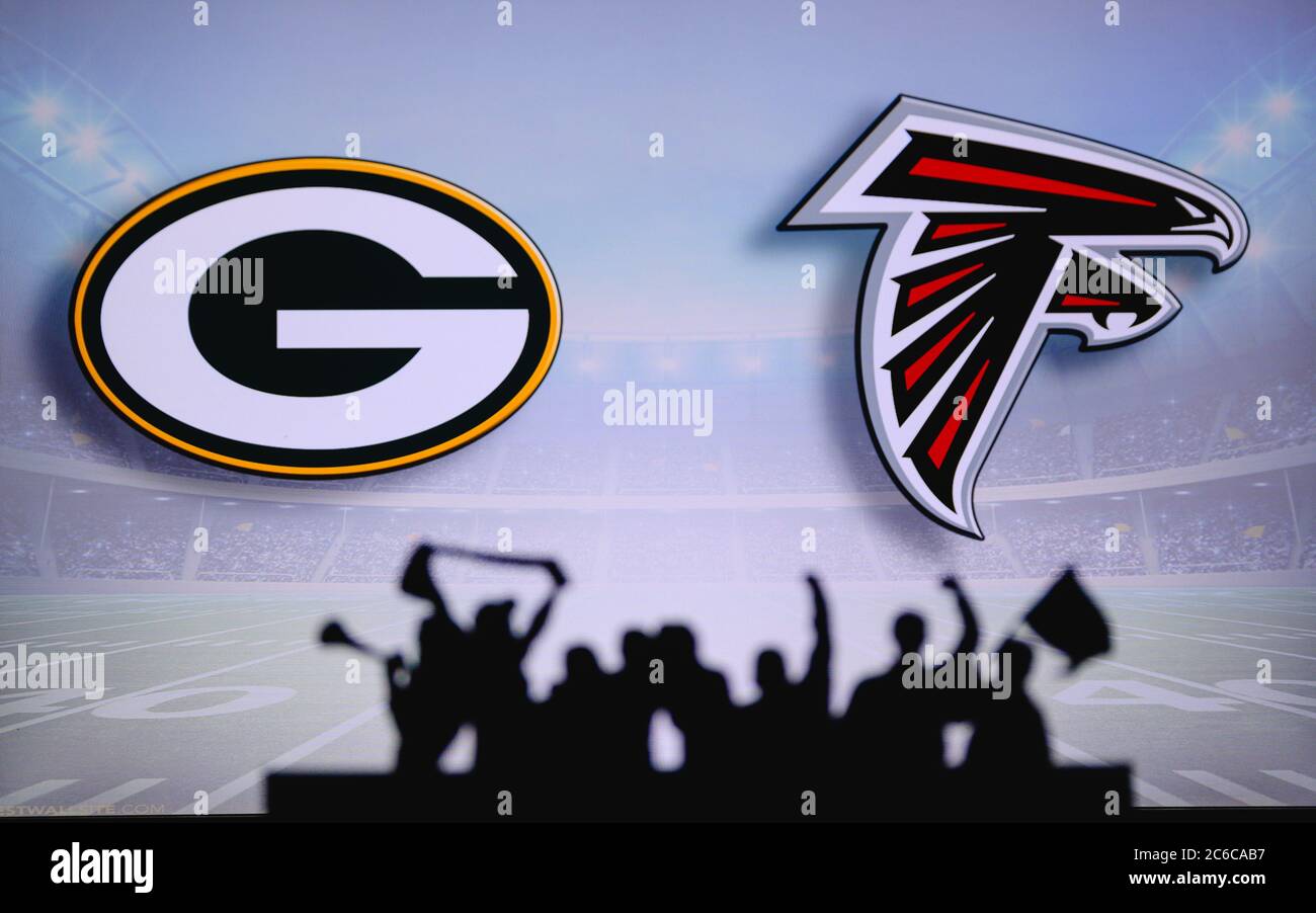 Green Bay Packers vs. Atlanta Falcons. Fans support on NFL Game. Silhouette of supporters, big screen with two rivals in background. Stock Photo