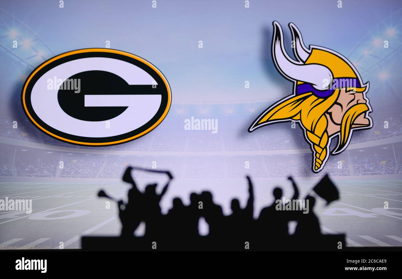 Green Bay Packers vs. Minnesota Vikings. Fans support on NFL Game. Silhouette of supporters, big screen with two rivals in background. Stock Photo