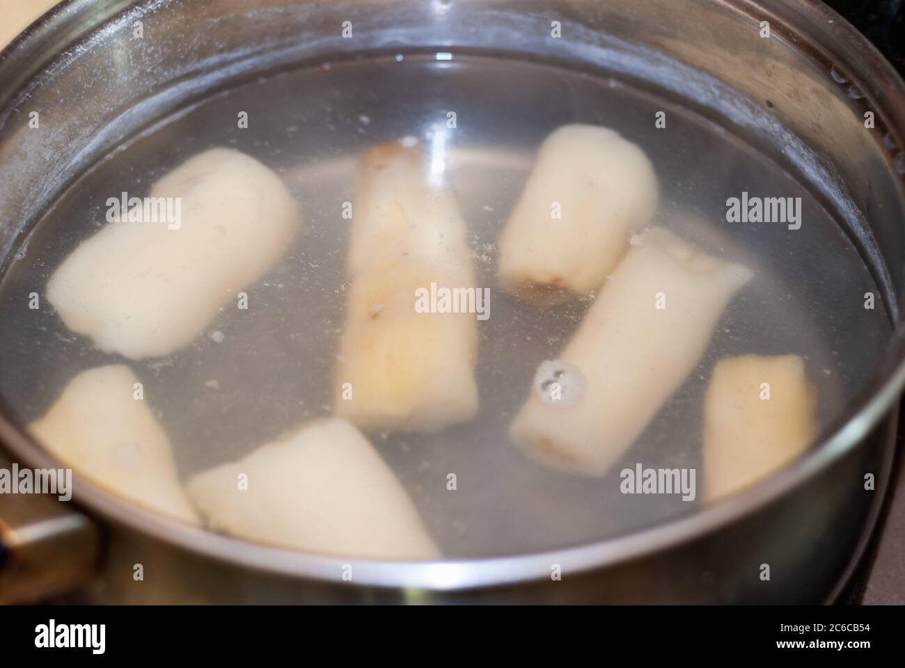 cooking cassava in a pot with boiling water, Manihot esculenta. Cassava, also called mandioca, yuca, balinghoy, mogo, mandioca, kamoteng kahoy, tapioc Stock Photo